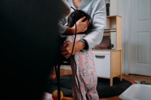 woman in gray cardigan and pink floral dress holding black coated wire